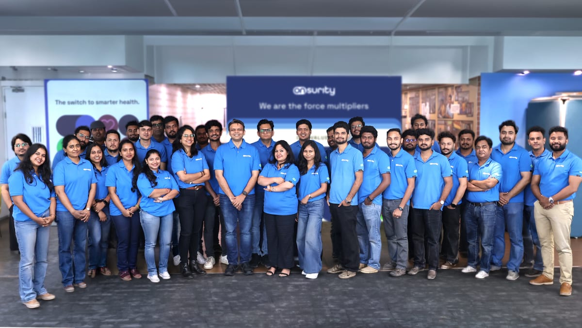 The Onsurity team together at the office in front of the “We are the force multipliers” wall