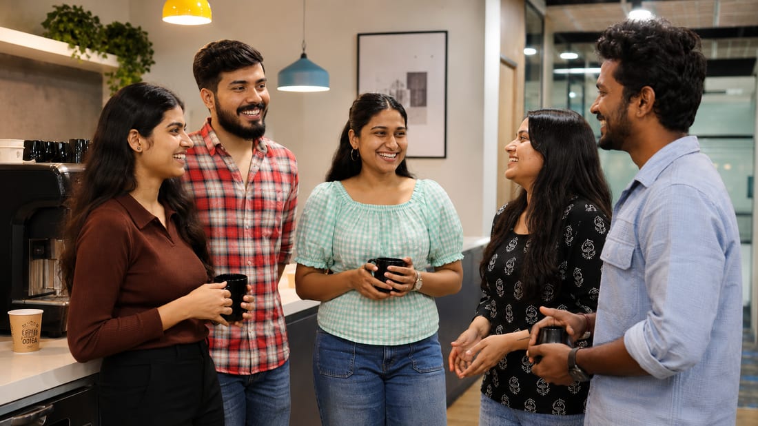 Onsurity teammates chatting over coffee in the office pantry